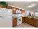 Modern kitchen featuring wood cabinets and white appliances at 3764 Ivey Ter, The Villages, FL 32163