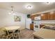 Kitchen boasts wood cabinets, white appliances, and a dining area at 3764 Ivey Ter, The Villages, FL 32163