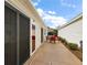 Patio with red chairs, glass table, and sliding glass door access at 3764 Ivey Ter, The Villages, FL 32163