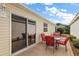 Small patio with red chairs and a glass table at 3764 Ivey Ter, The Villages, FL 32163