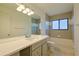 Bathroom featuring a large mirror, modern vanity, and tiled shower-tub with a window at 4668 Tower Pine Rd # Ge, Orlando, FL 32839