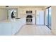 Modern white kitchen with stainless steel appliances and an eat-in island at 4668 Tower Pine Rd # Ge, Orlando, FL 32839