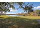 Serene lake view with bench, grass, and autumnal trees at 4668 Tower Pine Rd, Orlando, FL 32839