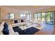 Open living area featuring hardwood floors, white sofas, and access to a patio with views of the garden at 4668 Tower Pine Rd # Ge, Orlando, FL 32839