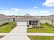 House exterior featuring a gray exterior, white garage door, and landscaping at 4861 Panga Ave, Mount Dora, FL 32757