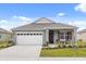 Gray house with white garage door, red shutters, and landscaping at 4861 Panga Ave, Mount Dora, FL 32757