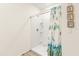 Shower stall with a white tile surround and floral shower curtain at 4861 Panga Ave, Mount Dora, FL 32757