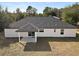 Rear view of house showcasing a covered patio and landscaping at 51 Aspen Rd, Ocala, FL 34480