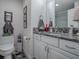 Bathroom with granite countertop, white cabinets and a shower at 5570 Parkyn Path, The Villages, FL 32163