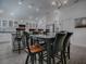 Kitchen dining area with black table, wooden chairs, and chandelier at 5570 Parkyn Path, The Villages, FL 32163