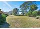 Landscaped backyard with lush lawn and mature trees at 6027 Spinnaker Loop, Lady Lake, FL 32159