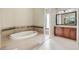 Bathroom with garden tub, wood vanity, and large mirror at 6027 Spinnaker Loop, Lady Lake, FL 32159