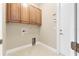 Well-lit laundry room with upper cabinets and space for washer and dryer at 6027 Spinnaker Loop, Lady Lake, FL 32159