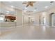 Open living room with tile floors, kitchen island, and access to a lanai at 6027 Spinnaker Loop, Lady Lake, FL 32159