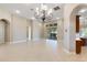 Bright living room with tile floors, chandelier, and sliding doors to patio at 6027 Spinnaker Loop, Lady Lake, FL 32159