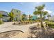 A peaceful courtyard features a gravel path, native plantings, and brightly colored homes at 8059 Knee Deep Rd, Kissimmee, FL 34747