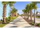 Lush, tropical landscaping lines a wide community walkway, offering a relaxing neighborhood stroll at 8059 Knee Deep Rd, Kissimmee, FL 34747