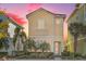 Tan three-story house with light-colored accents, landscaping, and palm trees at 8059 Knee Deep Rd, Kissimmee, FL 34747