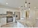 Modern kitchen featuring stainless steel appliances, granite countertops, and stylish pendant lighting at 8338 Se 178Th Deveaux Ln, The Villages, FL 32162