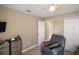 Cozy bedroom with a comfortable armchair, closet, ceiling fan, and neutral walls providing a relaxing space at 8920 Bridgeport Bay Cir, Mount Dora, FL 32757