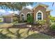 Charming home showcasing arched windows and a beautifully landscaped front yard, enhancing its curb appeal at 8920 Bridgeport Bay Cir, Mount Dora, FL 32757