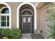 Elegant front entrance with a decorative door and arched window, providing a welcoming first impression at 8920 Bridgeport Bay Cir, Mount Dora, FL 32757