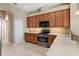 Bright kitchen features wooden cabinets, stainless steel appliances, and light tiled floor at 8920 Bridgeport Bay Cir, Mount Dora, FL 32757