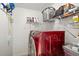 Modern laundry room with red front-loading washer and dryer, white shelving, and ample storage space at 8920 Bridgeport Bay Cir, Mount Dora, FL 32757