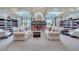 Inviting library with sofas, chairs, and extensive bookshelves creating a relaxing retreat at 8920 Bridgeport Bay Cir, Mount Dora, FL 32757