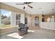 Living room features large windows with shutters, a ceiling fan, and view to the kitchen at 8920 Bridgeport Bay Cir, Mount Dora, FL 32757