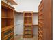 Walk-in closet with wooden shelving and drawers to maximize storage and organization at 8920 Bridgeport Bay Cir, Mount Dora, FL 32757