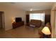 Living room with tiled floors, tan couches, and built-in shelving at 9401 Se 132Nd Loop, Summerfield, FL 34491