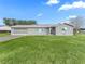 Gray house with teal accents, two-car garage, and spacious lawn at 9897 Se 178Th Pl, Summerfield, FL 34491