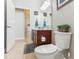 Bathroom with wood cabinets, toilet and view into another room at 10291 Se 69Th Ter, Belleview, FL 34420