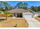 One-story home with a two car garage, palm trees and American flag at 10291 Se 69Th Ter, Belleview, FL 34420