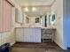 Bathroom vanity with white cabinetry, wood-look floors, and pink window blinds at 114 Chestnut St, Leesburg, FL 34748