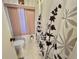 Bathroom featuring floral shower curtain, pink window blinds, and toilet at 114 Chestnut St, Leesburg, FL 34748
