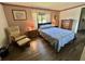 Bedroom featuring a queen bed, striped wallpaper, hardwood floors, and traditional furnishings at 114 Chestnut St, Leesburg, FL 34748