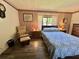 Bedroom featuring a queen bed, striped wallpaper, hardwood floors, and chair and ottoman at 114 Chestnut St, Leesburg, FL 34748