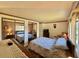 Bedroom featuring a queen bed, striped wallpaper, hardwood floors, and mirrored closet doors at 114 Chestnut St, Leesburg, FL 34748