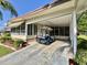 The carport has room for a vehicle and offers covered access to the home with a screened porch entry at 114 Chestnut St, Leesburg, FL 34748