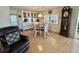 Cozy dining area with a table set for four, complemented by white cabinets and hardwood floors at 114 Chestnut St, Leesburg, FL 34748