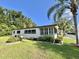 Inviting home boasts a well-maintained lawn, complemented by manicured landscaping and charming shutters at 114 Chestnut St, Leesburg, FL 34748