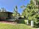 The side yard features mature trees and manicured green space, offering a serene setting next to the property at 114 Chestnut St, Leesburg, FL 34748