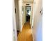 Long hallway with light wood flooring and access to bedrooms at 114 Chestnut St, Leesburg, FL 34748