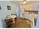The kitchen features white cabinets, tiled backsplash, and a cozy breakfast table with seating for two at 114 Chestnut St, Leesburg, FL 34748