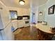 View of the kitchen with white appliances, tile backsplash, breakfast table, and light blue accent wall at 114 Chestnut St, Leesburg, FL 34748