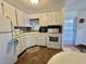 Bright kitchen showcasing white appliances, a modern microwave, and neutral backsplash for a clean look at 114 Chestnut St, Leesburg, FL 34748