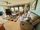 Comfortable living room featuring hardwood floors, plush sofas, decorative curtains, and a ceiling fan at 114 Chestnut St, Leesburg, FL 34748