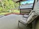 Covered patio area featuring comfortable seating and a lattice privacy screen offers a tranquil outdoor retreat at 114 Chestnut St, Leesburg, FL 34748